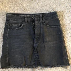 Svart jeanskjol från Gina Tricot - Kort, svart jeanskjol med urtvättad look från Gina. Använd men i bra skick.