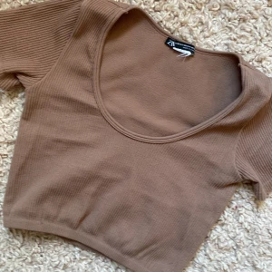 Brun croppad t-shirt  - Säljer en brun t-shirt pågrund av den inte används längre! Den är som ny och är i storlek xs!😻