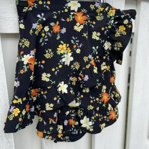 Shorts/kjol - Svart/blommiga shorts som ser ut som en kjol i storlek XS/S. Använd fåtal gånger och är i bra skick:) 