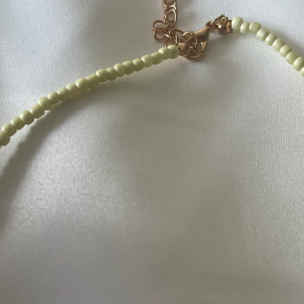 Pärl halsband med justerbart längd i bak och färg gul . Accessoarer.