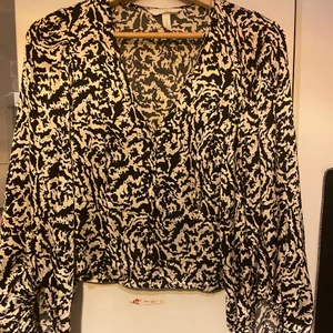 Blus från hm - Beige och svart mönstrad satin blus med urringning och ballong ärmar. Endast använd 1 gång. 