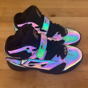 Fila stl 38 - Snygga Höga fila sneakers i stl 38. Bra passform. Har reflex detaljer med spännen. Använda ca 3 ggr inomhus. Är i jättebra skick!  Köpes för 450 kr prutat och klart! skickas spårbart med PostNord frakt ingår ej.