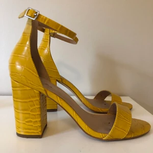 Gula klackar  - Gula klackar i krokodilmönster. Storlek 37 från New Look. Klackhöjd: 10 cm. Använda en gång.