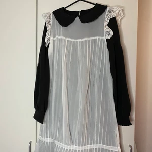 Klänning - två delar  - Två delad klänning (svart och vit överklänning)  endast använd för fota med. Tredje är hur jag stylat den med en kjol och en brosch. 