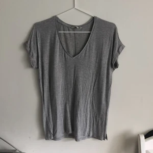 Grå V-ringad t-shirt - Grå tröja med v-ringad krage. Använd, bra skick.