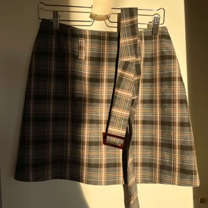 Rutig kjol - Säljer denna jättesöta kjol då den inte längre kommer till användning.🤎 Den har ett skärp men brukar ta av det och egentligen  aldrig använda det. Den är ca 45 cm lång men brukar boka upp den för att göra den kortare. Storlek 38. Skriv om du har några frågor eller vill ha fler bilder🥰 pris kan alltid diskuteras