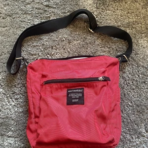 Axelremsväska i rött från Marimekko - Axelremsväska från Marimekko i rött, används inte därför säljs den:)  Måtten är följande: 13cm Djup, ca 30 cm bred, 28cm lång & bandet är justerbart men kan längs bli 118 cm 😊 köpare står för frakt🥰❤️‍🔥