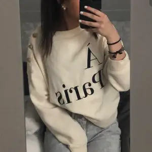 beige sweatshirt med trycket Á Paris och guldiga knappar vid axeln. Från h&m i storlek xs men ganska oversized. 😇