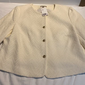 Kavaj  - Långärmad kavaj i strukturvävd kvalite av bouclegarn. Kavajen har en rund halsringning samt guldfärgade knappar framtill samt vid ärmslut, fodrad. Kavajen är helt ny och aldrig använd, jag köpte den i England gör ca 3 år sedan. Storleken är 50 vilket är en XL. 