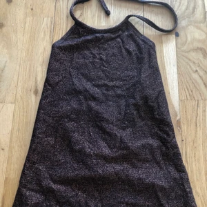 Halterneck linne glittrig - Rostbrun glittrig halterneck linne köpt från Östermalm i en mindre butik. Fanns en ros sätta på linnet men e borta tyvärr. En fest och party halterneck.