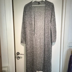 Grå stickad kofta  - Lång, grå stickad kofta från H&M. Sparsamt använd så i mycket bra skick. Den är i storlek M men passar bra i S. Den har slitsar på båda sidorna, se bild 3.