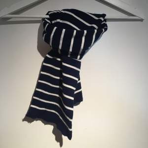 Marinblå och vit randig halsduk. Färgen är mer som på bild 3. Ca 40 cm lång. 