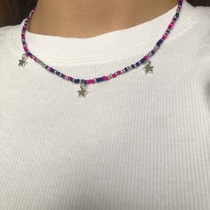 Ett Stockholmsstil Halsband Som har färgerna silver rosa blå och silvriga stjärnor. Halsbandet är elastisk och har en förlängningskedja! FRAKT INGÅR!💜