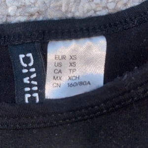 En svart tröja från H&M  - En svart tröja men em vit rand där nere där de står” DES SPORTS” den är ganska kort som en magtröja och är i storleken XS