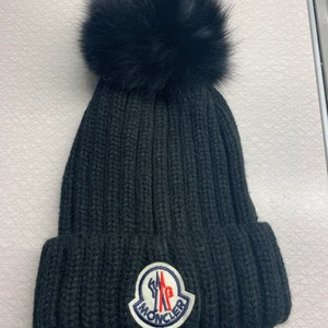 Moncler mössa - Svart Moncler mössa med avtagbar äkta pälsboll🖤 eftersom de va så stort intresse av mössan så tänkte jag starta bud istället