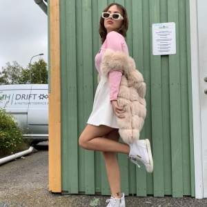 long length faux fur gilet in blush pink. 