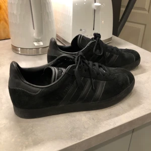 Adidas svarta sneakers - Adidas svarta sneakers i mocka. Storlek 38,5. Fint skick! Kan mötas Stockholm Högdalen tunnelbana 