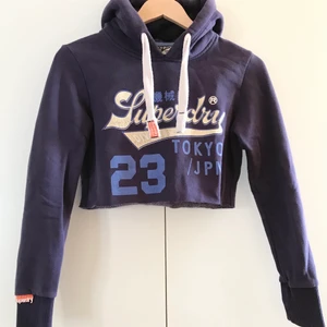 Superdry cropped hoodie  - Plagget är något mindre i storleken och har inga tydliga tecken på användning förutom slitet tryck. Skriv vid intresse och betalning sker via Swish💜