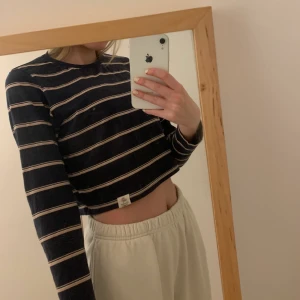 Randig tröja från Pull&bear  - Jättesöt croppad tröja från Pull&bear. Mörkblå med rosa ränder, samt en detalj längst ner, se sista bilden. Använd cirka 5 gånger, inte fått tillfälle så ofta. Köpt för 39 euro. Skick 10/10. Storleken är xs men passar bra på mig som brukar ha s.
