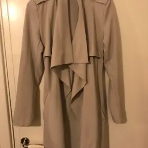 En kappa/trenchcoat från object collectors item som är ljus grå. Den är i strl xs men passar nog någon med s också.