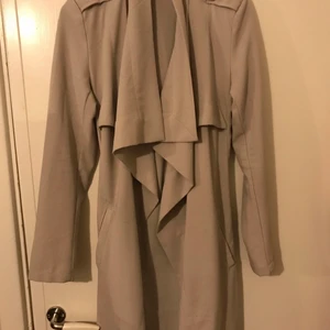 Grå kappa - En kappa/trenchcoat från object collectors item som är ljus grå. Den är i strl xs men passar nog någon med s också.