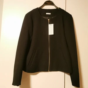 Kort jacka - Superfin ny lite kortare svart jacka. Se sista bild för material. Aldrig använd, lappar kvar. Storlek L men passet nog M också. Köparen står för frakten, men vet inte exakt kostnad nu. 