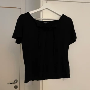 T-shirt med snörning - En svart t-shirt med snörning från boohoo. Storlek 14 (42) men är rätt liten.