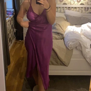 Lila satinklänning - Säljer denna satinklänning med slits, helt oanvänd prislapp kvar. Köpt på zara. Sitter jättefin på med snörning i ryggen!