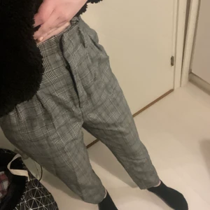 Grårutiga kostymbyxor - Grårutiga kostymbyxor från hm i storlek 34. De hade ett band runt midjan innan men har tappat bort det, funkar fint även utan.
