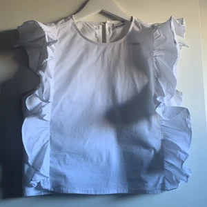 Vit topp med volanger  - Vit söt topp med volanger, från gina storlek xs⭐️⭐️⭐️ köparen står för frakten