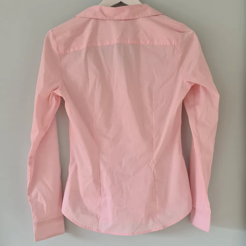 En rosa skjorta från H&M som aldrig använts och är därför i fint skick!. Skjortor.