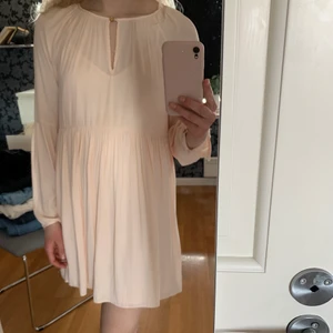 Ljusrosa klänning  - Ljusrosa klänning från Nelly, sparsamt använd i nyskick. Slutar strax över knäna på mig som är 172 cm lång. Saknar en knapp (se bild) men är lätt att åtgärda. Den består av två delar (under-/överklänning). Skönt och luftigt material. Storlek 40.