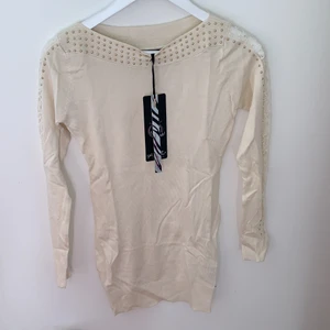 Kort klänning/ långtröja  - Kort klänning/ långtröja i färgen vit/beige/ kräm, storlek S/M. Armlängderna är i spets. Helt ny och aldrig använd. Från märket Koucla Fashion.