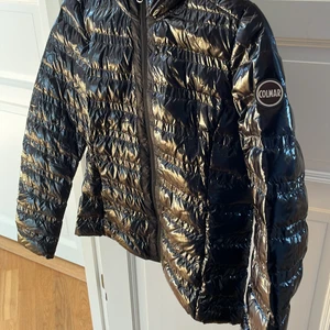 Colmar jacka  - Säljer den här superfina svarta colmar jackan. Den är i ett superfint glansigt material med matta detaljer som man ser på bilden vid dragkedjan. Den har en superbra luva också. Köptes på colmar butiken i Chamonix och den är väldigt lite använd och är i mycket fint skick. 