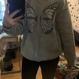 Grå kofta med fjäril - Grå kofta med en fjäril på. Aldrig använd!