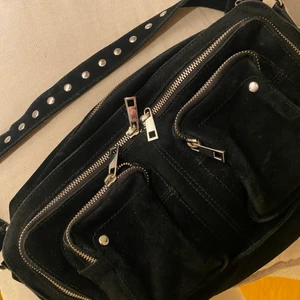 Núnoo väska - svart  - Núnoo Alimakka New suede black väska. Använd ett fåtal gånger, endast ytterst lite sliten på dragkedjan. Nypris: 1599 sek 