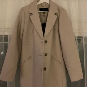 Ljusbeige vårkappa - En jättefin ljusbeige kappa! Aldrig använd, lappar kvar! 