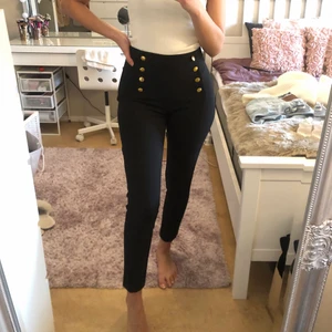 Svarta kostymbyxor från h&m - Svarta kostymbyxor med guldknappar, köpt från h&m i storlek 36. Sitter som en smäck o har dragkedja på sidan. Helt oanvända. 