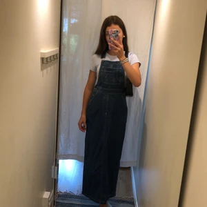 Jeansklänning - Skitsnygg jeansklänning med hängslen! 🙌 Är strl 34 vilket är typ xs. Knappt använd alls så är i mkt fint skick! Har en ficka i fram, två vid midjan och två i bak. Går till anklarna på mej som är 167 men går att spänna axelbanden så att den blir längre. Köpare står för frakt. Tveka inte att kontakta vid frågor! 💖