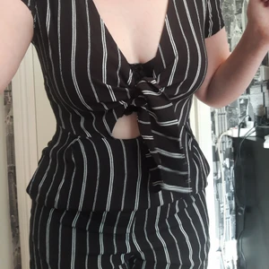 Playsuit - Svart och vit randig playsuit med fickor. Knytning på framsidan med en liten öppning under. Låmg dragkedja på ryggen. Storlek: Står M men skulle snarare säga S. Material: Viskos. Hål i höger arm (sista bilden) men annars inga skador.