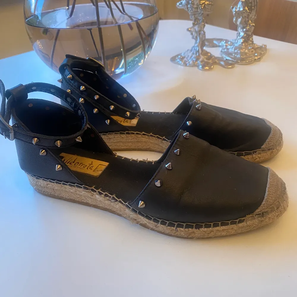 Espadrillos i svart skinn med silvernitar. Köpta i Italien men made in Spain,  bra kvalite.  Storlek 38, normala i storleken. Bruksslitage . Skor.