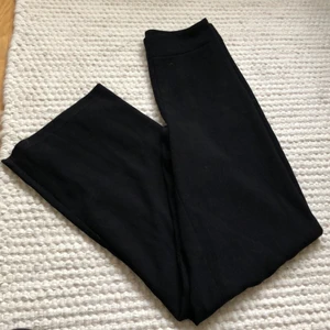 Kostymbyxor Gina Tricot storlek 36 - Svarta vida kostymbyxor från Gina Tricot med dragkedja i sidan. Sömmen sprucken i sidan vid dragkedjan, se detaljbild. Kan säkert sys av den händiga. Därav det låga priset. Annars superfina! 