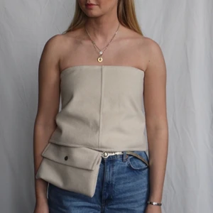 Beige korsett top - Beige korsett top med knytning i ryggen. Gjord av restmaterial från jacka! Ursprungligen från H&M som är omgjord av Scannable UF. Genom att skanna en QR-kod som finns fäst på plagget kan du läsa mer om materialet och dess miljöpåverkan!✨✨