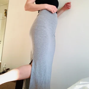 Grå långkjol - Grå långkjol o mjukis-material. Slits på båda sidor, går hela vägen till fötterna på mig som är 168. Använt skick