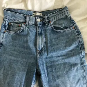 Högmidjade jeans från Gina Tricot i rak modell.  Avklippta nedtill. Innerbenslängd cirka 65 cm. Storlek 36.  Använda men i bra skick. 
