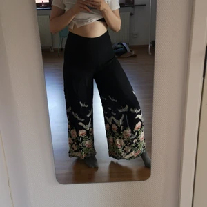 Somriga byxor med de finaste detaljerna - Sköna, lätta byxor som är väldigt flowy.  Har slits på sidorna och knäpps med dragkedja där bak. 