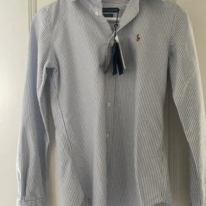 Ralph lauren skjorta  - Säljer min skjorta som tyvärr är för liten för mig🥲 som ni ser sitter pris lappen kvar. Fick den för något år sen men den kom aldrig till användning då den va liten. 