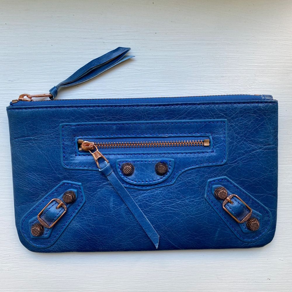 Liten Balenciaga (ej äkta) inspirerad kuvertväska/plånbok. Aldrig använts och i äkta läder. En tråd som är lite lös framtill (se bild 2) därav lågt pris. Mått: 20x12 cm. Väskor.