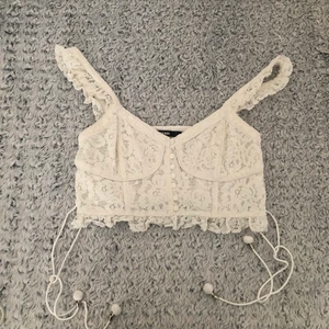 Säljer min snygga spets top! 🤩 - Säljer min fina spetstopp som jag använt några gånger men den är i perfekt skick! Toppen har snörrning på båda sidorna av midjan som man kan justera! Väldigt snygg