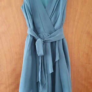 Omlottklänning  - grön omlottklänning men snöre i midjan. Hällorna har tyvärr släppt men det går att använda bandet ändå. 